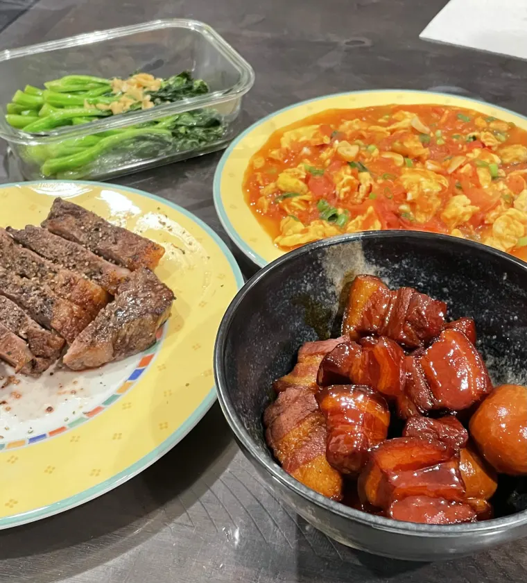 A home-cooked dinner — steak, tomato egg, greens and braised pork